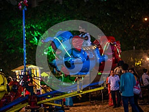 Indian kids enjoying carousel ride in elephant at amusement park