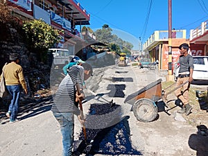 Indian labours filling pot holes in market