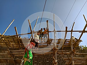 indian labours making wooden structure for wall plaster work on site in India January 2020