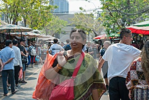 Indian lady is carrying plastic bag looking for things to buy