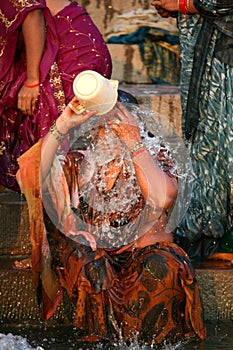 An indian lady washing in the ganges river