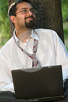 Indian with a laptop smiling