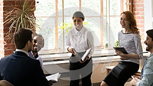 Indian leader and diverse staff laugh at meeting in office