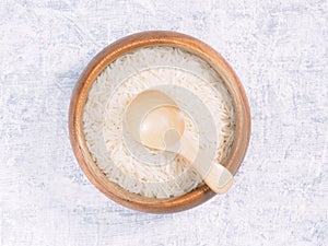 Indian long grain Basmati rice in brown wooden bowl and spoon