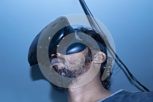 Indian looking man using VR technology on blue light