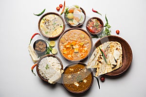 Indian lunch or dinner items like dal, paneer butter masala, roti, rice, salad