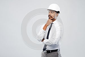 Indian male architect in helmet over grey