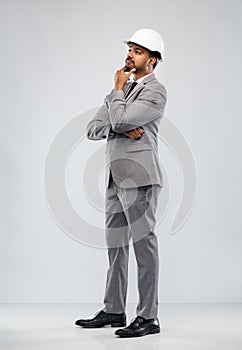 Indian male architect in helmet over grey