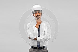 Indian male architect in helmet over grey