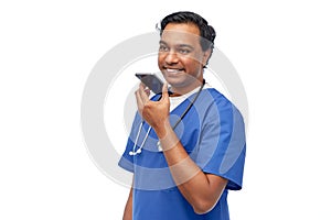 indian male doctor recording voice with smartphone