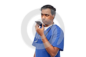 indian male doctor recording voice with smartphone