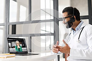 Indian male doctor with a stethoscope giving consultation to patient online