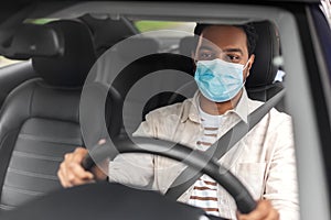 indian male driver in mask driving taxi car