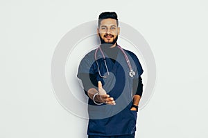 Indian Male medicine doctor offering hand to shake. Greeting and welcoming gesture. Medical cure and tests advertisement concept.