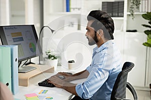 Indian male office worker, Working on analyzing statistics charts, Accounting officer work financial graphs with computer, HR