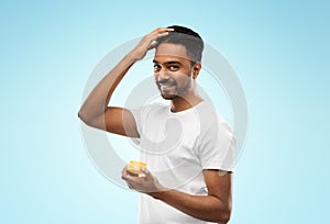 Indian man applying hair wax or styling gel