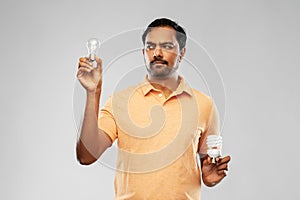 Indian man comparing different light bulbs