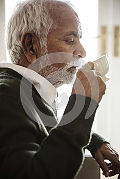 Indian man drinking hot tea at home photo