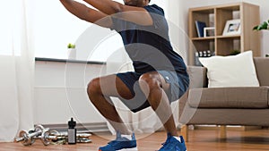 Indian man exercising and doing squats at home