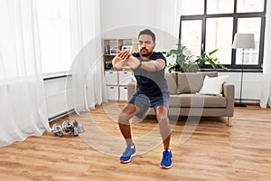 Indian man exercising and doing squats at home