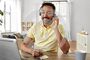 Indian man with headset and laptop working at home