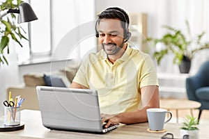 Indian man with headset and laptop working at home