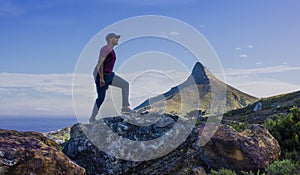 Indian man hiking and jumping, made to look like he is walking up Lions Head Mountain.