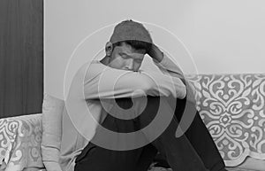 indian man at home living room sofa feeling desperate suffering depression black and white