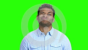 Indian man making funny faces on green screen.
