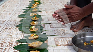 An Indian man offers food to the souls of his deceased family members during Shradh. Indian customs and festivals