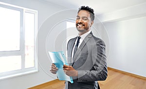 Indian man realtor with folder at new apartment
