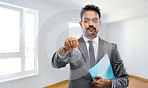 Indian man realtor with home keys and folder