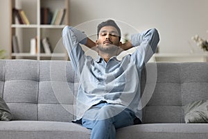 Indian man relaxing at home fell asleep leaned on couch