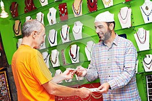 Indian man seller with buyer at the souvenir shop