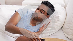 Indian man suddenly awaking and looking at phone