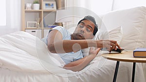 Indian man suddenly awaking and looking at phone