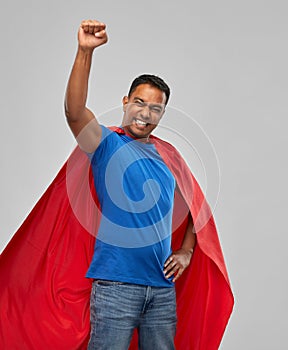 Indian man in superhero cape makes winning gesture