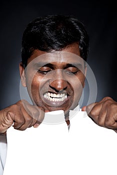 Indian man tearing paper sheet