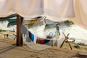 Indian man washing clothes in holy water of river Ganga in the morning. Varanasi. India