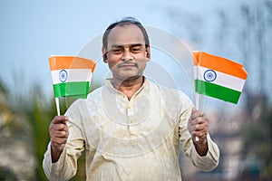 Indian man waving Indian Flags in air and celebrating Independence or Republic day