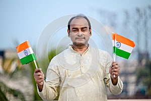 Indian man waving Indian Flags in air and celebrating Independence or Republic day