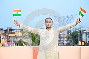 Indian man waving Indian Flags in air and celebrating Independence or Republic day