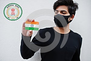 Indian man wear all black and face mask, hold India flag in hand isolated on white background with Chhattisgarh state emblem .