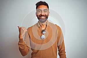 Indian man wearing elegant sweater and sunglasses standing over isolated white background smiling with happy face looking and