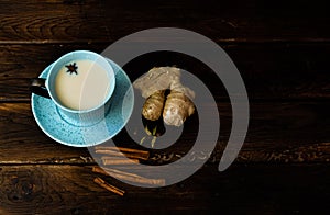 Indian masala chai tea. Masala chai spiced tea with milk and spices on dark rusty background.