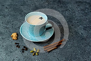 Indian masala chai tea. Masala chai spiced tea with milk and spices on dark rusty background.