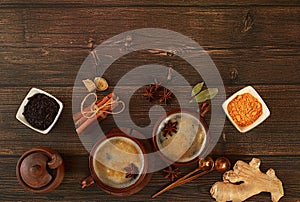 Indian masala chai tea with milk, ginger, anise and cinnamon on an old wooden table. Traditional drink with spices, cafe concept,