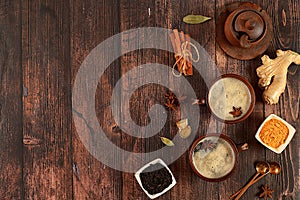 Indian masala chai tea with milk, ginger, anise and cinnamon on an old wooden table. Traditional drink with spices, cafe concept,