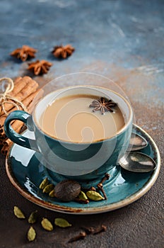 Indian masala chai tea. Spiced tea with milk on dark rusty background.