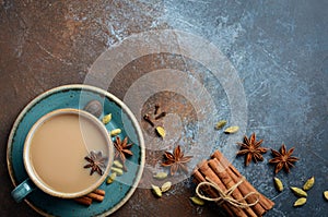 Indian masala chai tea. Spiced tea with milk on dark rusty background.